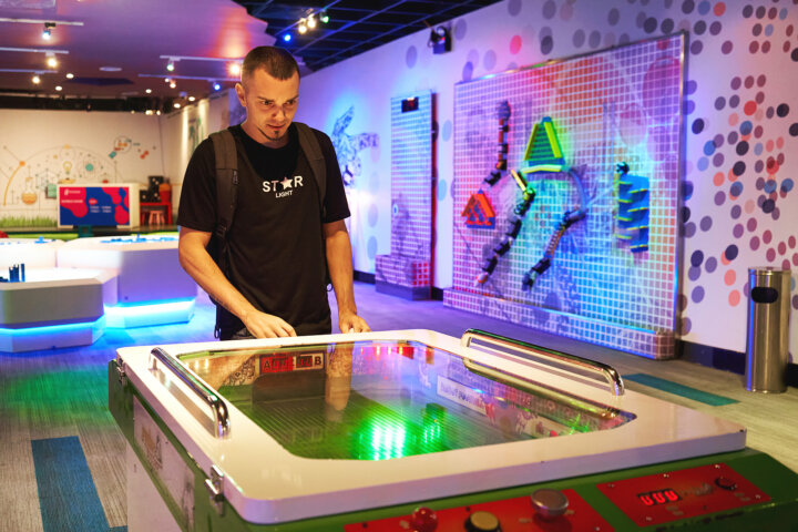 Dudes playing in air hockey